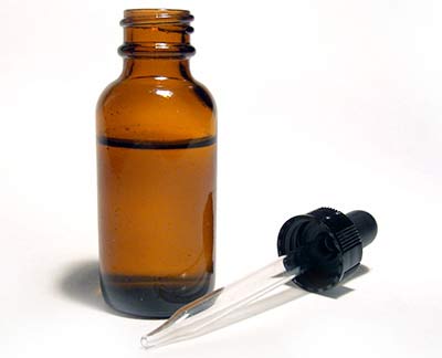 Conta gotas e frasco de vidro, ilustrando o uso do Minoxidil