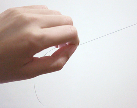 Mão puxando fio de cabelo, ilustrando post sobre tricotilomania